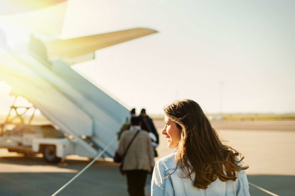 investment highlights - Woman on tarmac approaching steps to board plane